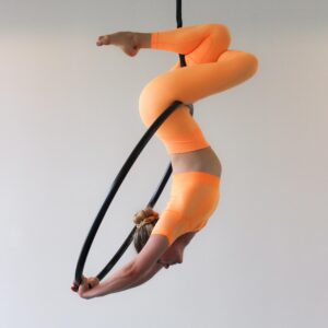 kvinde i orange tøj i en aerial hoop